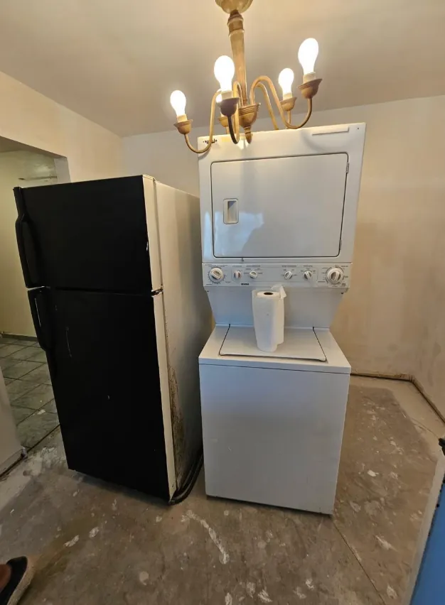 Refrigerator and stacked washer and dryer indoors